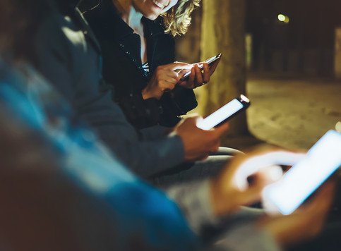 Photo of smiling people shopping on their phones